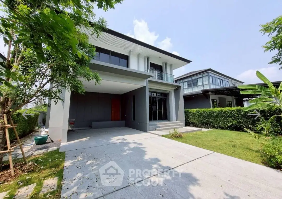 Modern two-story house with spacious driveway and lush garden