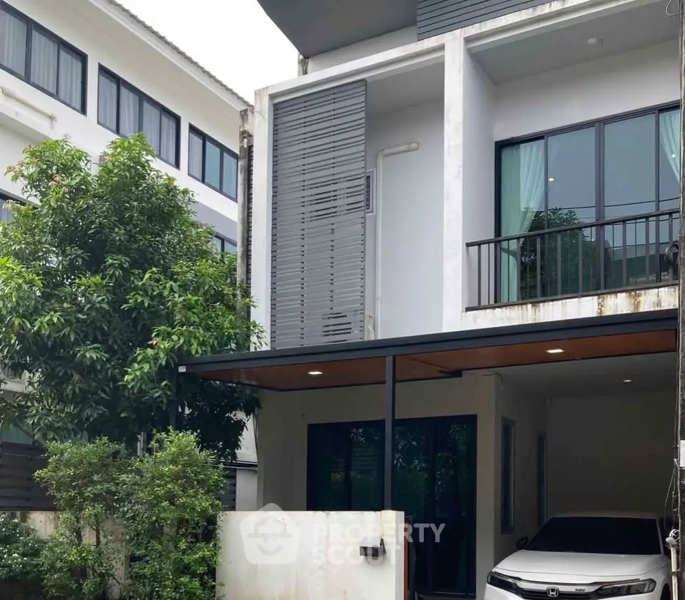 Modern townhouse with carport and lush greenery in urban setting