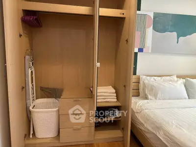 Spacious bedroom with modern wooden wardrobe and cozy bed setup.