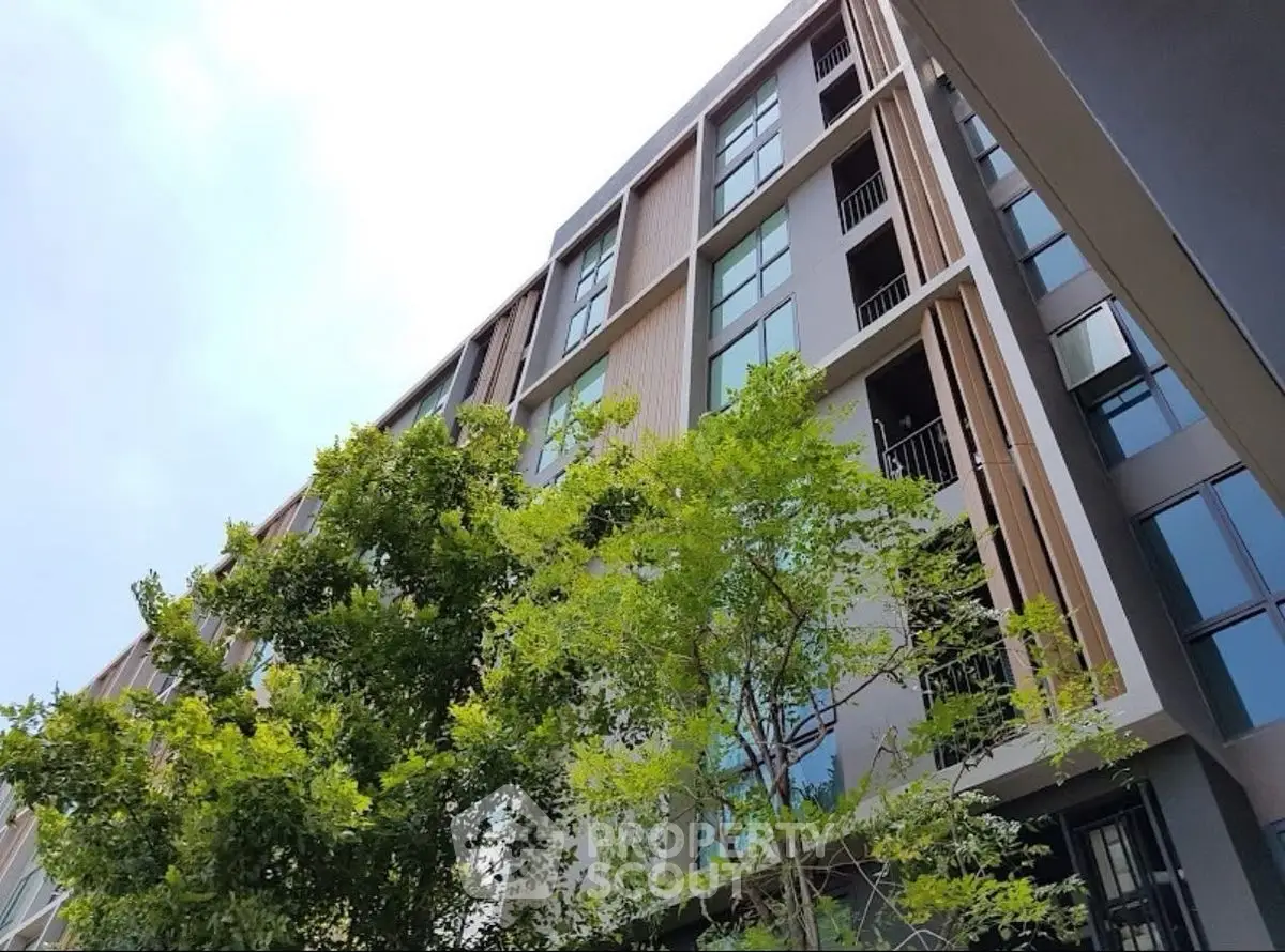 Modern apartment building with sleek design and lush greenery