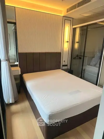 Modern bedroom with sleek design and ample natural light, featuring a comfortable bed and stylish decor.
