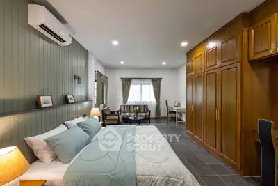 Spacious bedroom with elegant wood paneling and modern furnishings