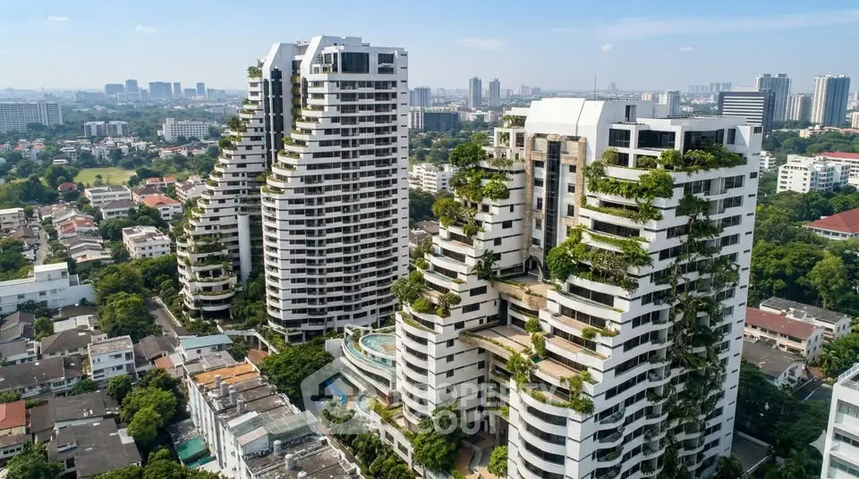 Stunning aerial view of modern high-rise buildings with lush greenery and cityscape backdrop.
