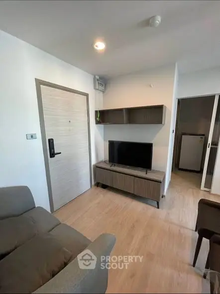 Modern living room with sleek furniture and TV, showcasing contemporary design and comfort.