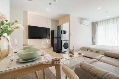 Modern studio apartment with open layout, featuring a cozy living area, dining space, and in-unit laundry.