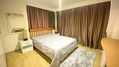 Spacious bedroom with elegant wooden furniture and cozy ambiance