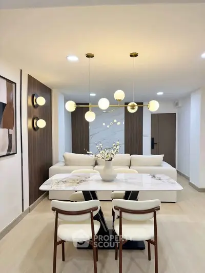 Modern living room with elegant dining area and stylish lighting fixtures.