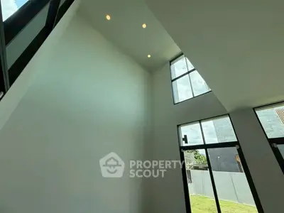 Spacious modern living room with high ceilings and large windows for natural light.