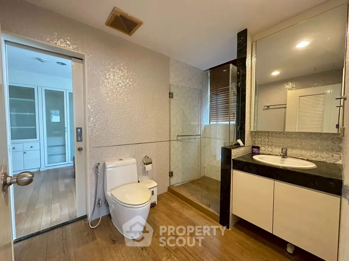 Modern bathroom with glass shower and elegant vanity in upscale home.