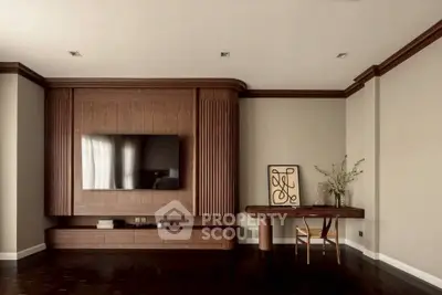 Elegant living room with modern wood paneling and mounted TV, featuring stylish decor and sleek furniture.
