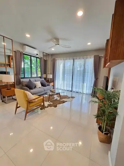 Spacious living room with modern decor and large windows offering natural light.