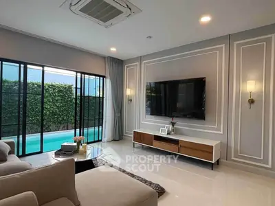 Luxurious living room with pool view, elegant decor, and modern amenities in a stylish home.