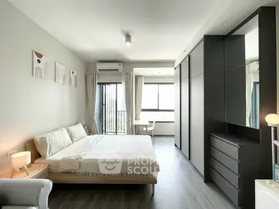 Modern bedroom with large windows and sleek furniture in a stylish apartment.