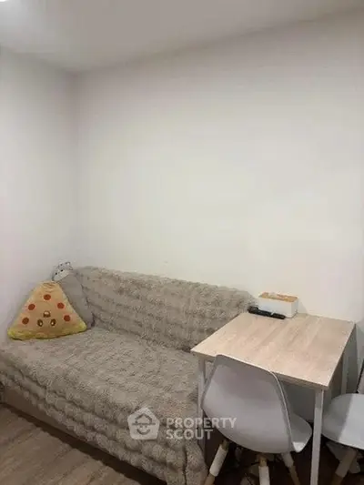 Cozy small living area with sofa and compact dining table, ideal for urban living.