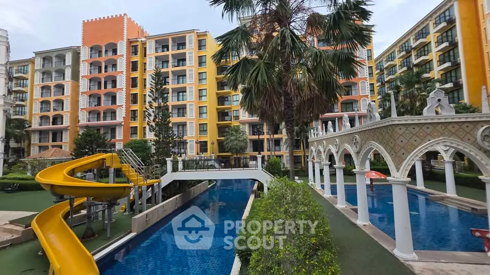 Luxurious apartment complex with pool and slide, vibrant architecture, and lush landscaping.