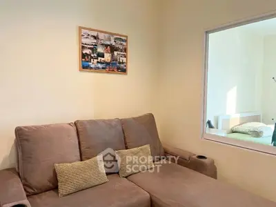 Cozy living room with comfortable sofa and wall art, perfect for relaxation.