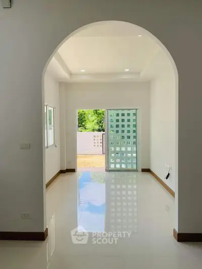 Spacious bright room with glossy floors and large sliding doors leading to a balcony.