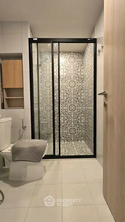 Modern bathroom with stylish patterned shower and sleek fixtures