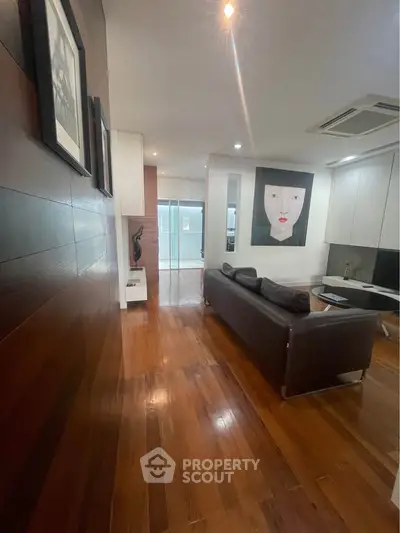 Stylish modern living room with wooden flooring and contemporary art, perfect for urban living.