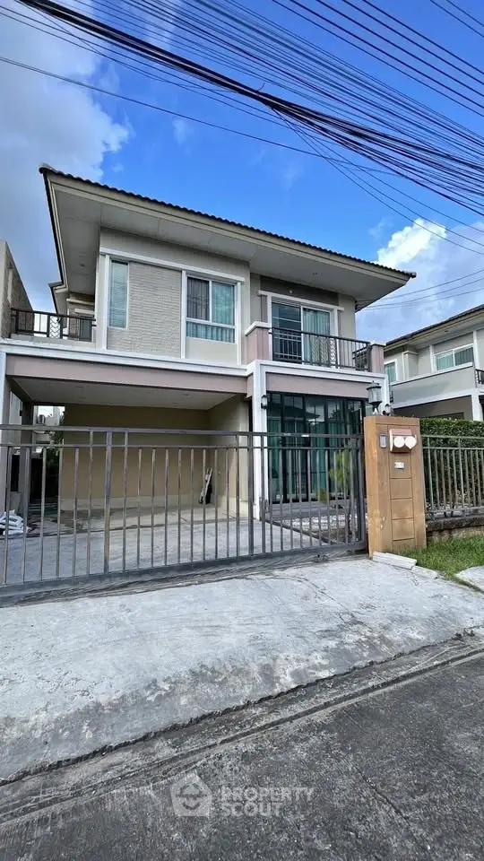 Modern two-story house with spacious driveway and gated entrance