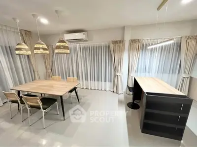 Modern dining area with stylish lighting and large windows in a contemporary home.