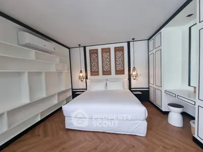 Luxurious modern bedroom with elegant decor and spacious design, featuring built-in shelves and stylish lighting.