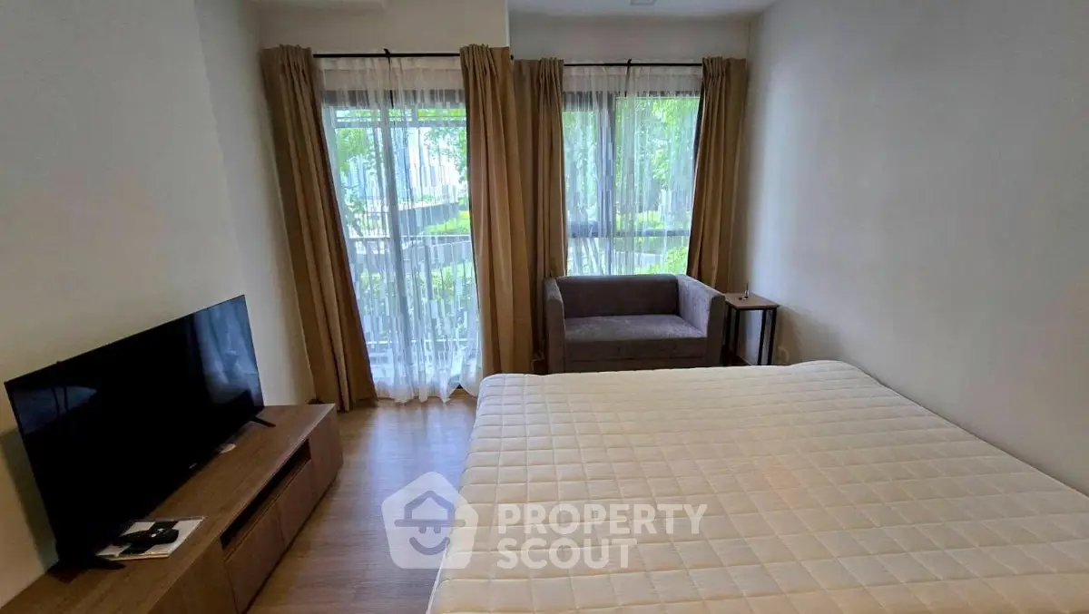 Cozy bedroom with large window and modern furnishings in a serene setting.