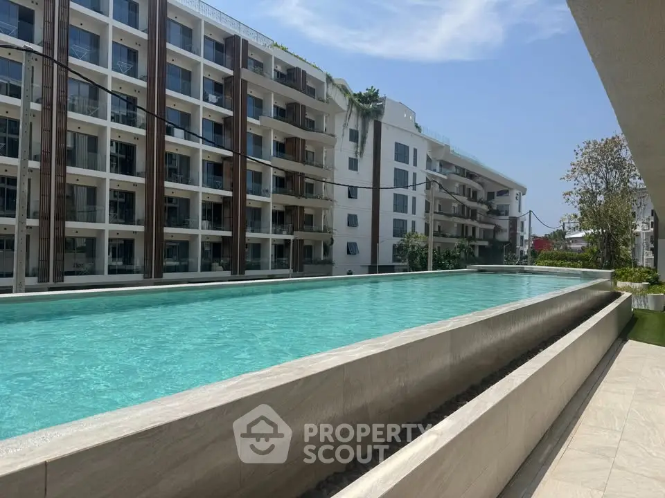 Luxurious apartment complex with a stunning rooftop pool and modern architecture.