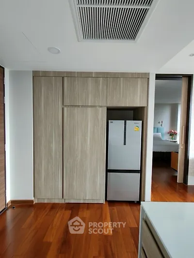 Modern kitchen with sleek wooden cabinetry and stainless steel fridge
