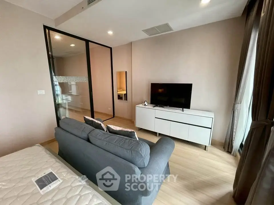 Modern living room with sleek TV stand and cozy sofa in stylish apartment.