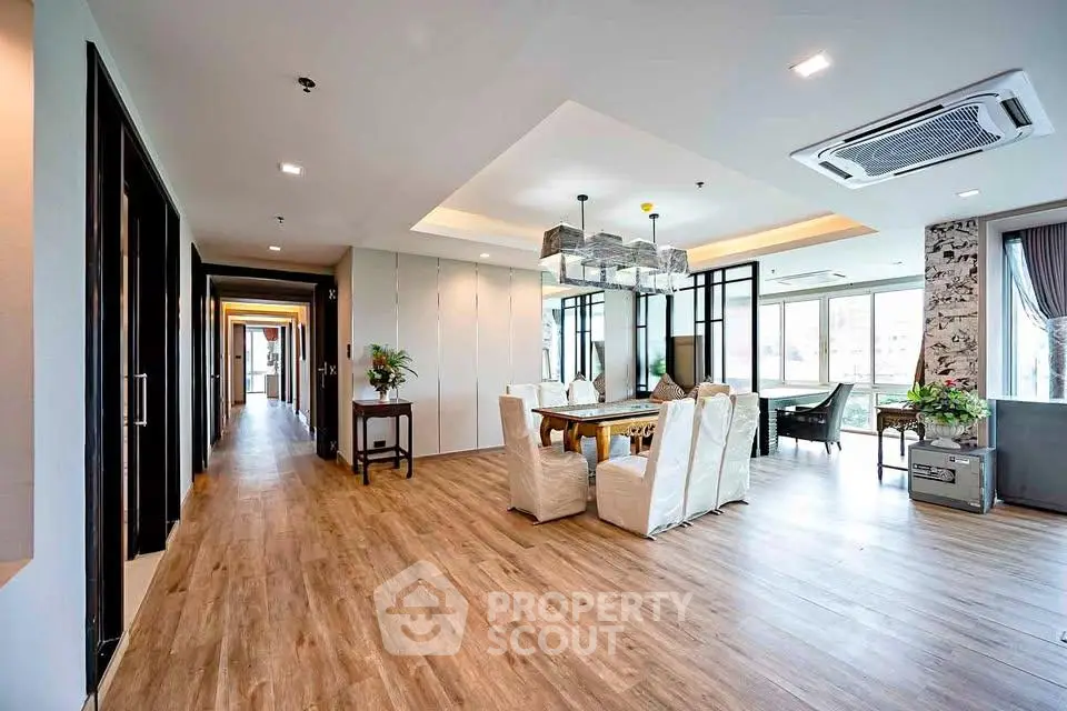 Spacious modern living room with elegant dining area and large windows offering natural light.