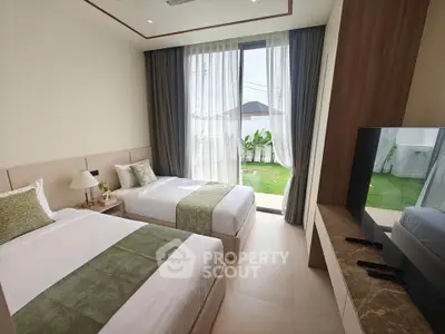 Modern bedroom with twin beds and garden view, featuring elegant decor and natural light.