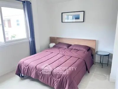 Cozy bedroom with modern decor and large window for natural light