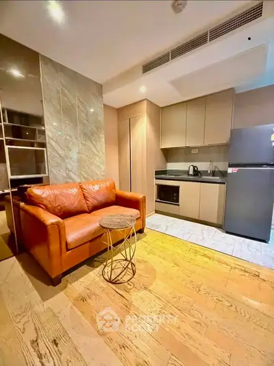 Modern living room with leather sofa and compact kitchen in stylish apartment
