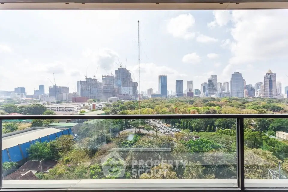Stunning cityscape view from a high-rise balcony overlooking lush greenery and urban skyline.