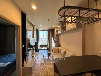 Modern living room with city view, cozy seating, and stylish decor in a high-rise apartment.