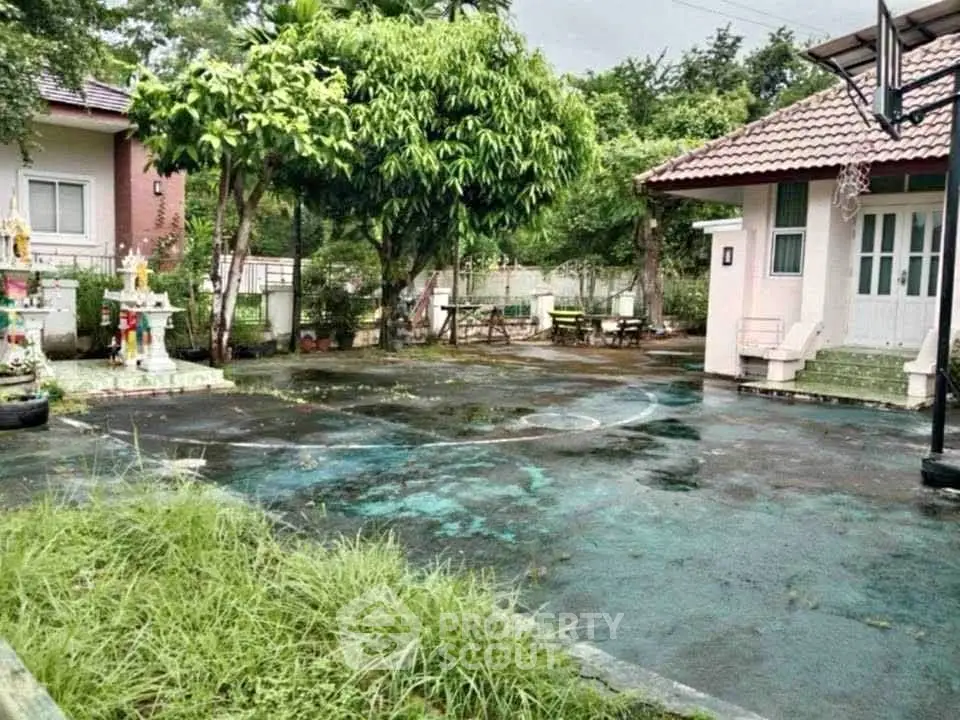 Charming residential property with spacious outdoor area and lush greenery, perfect for family gatherings.