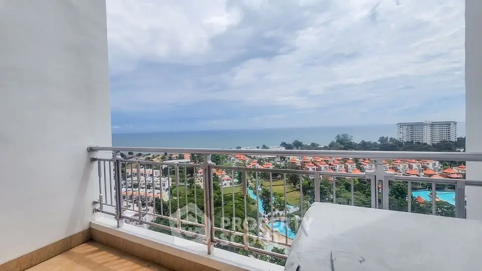 Stunning balcony view overlooking ocean and lush greenery in prime real estate location.