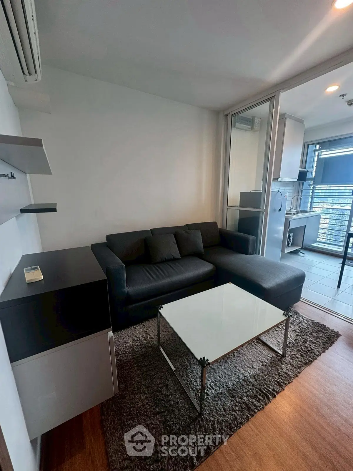 Modern living room with sleek furniture and open kitchen layout in a stylish apartment.