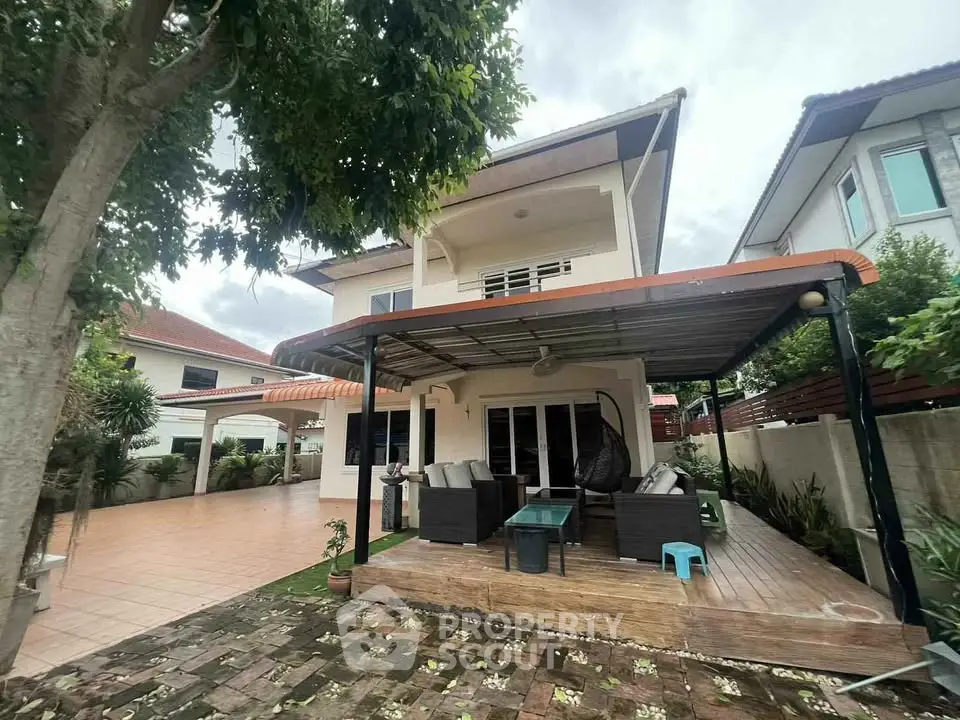 Charming two-story house with spacious patio and lush garden, perfect for outdoor relaxation and entertaining.