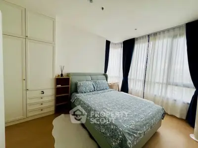 Spacious bedroom with elegant decor and large windows for natural light