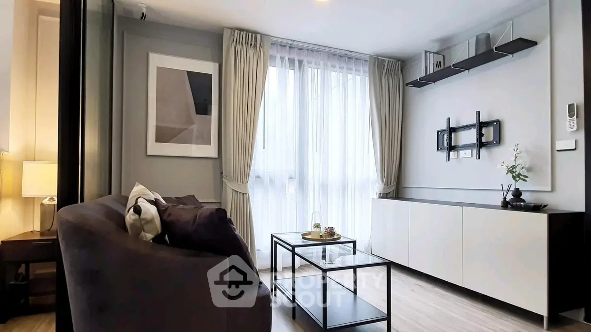 Modern living room with sleek furniture and large window, perfect for cozy gatherings.