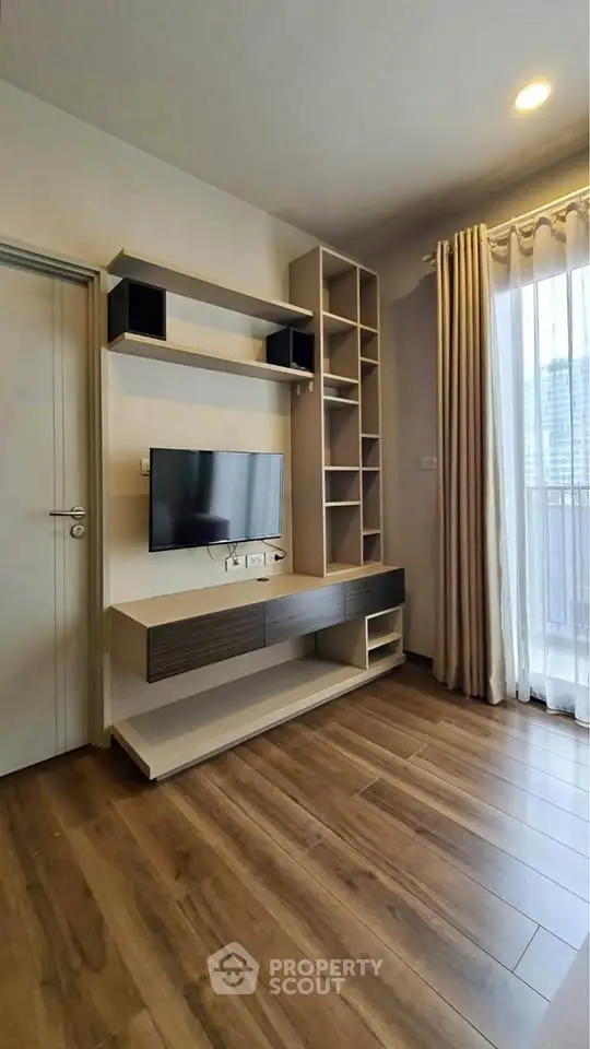 Modern living room with sleek TV unit and large window for natural light.
