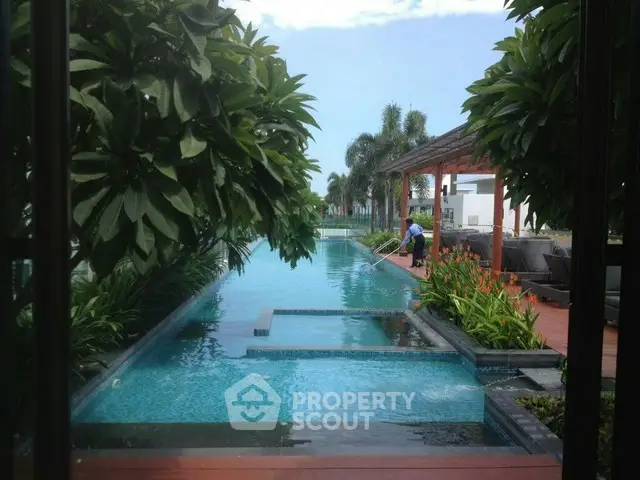 Luxurious outdoor pool area with lush greenery and modern seating, perfect for relaxation and leisure.