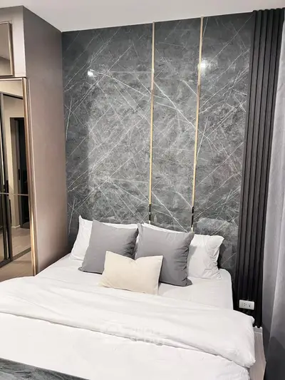 Luxurious bedroom with modern marble accent wall and elegant bedding