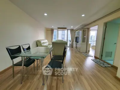Spacious living room with modern furniture and wooden flooring in a high-rise apartment.
