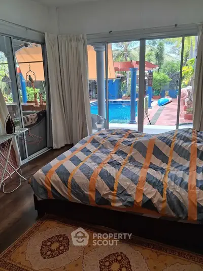 Spacious bedroom with pool view and large windows for natural light
