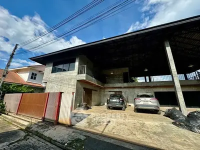 Modern industrial-style building with spacious parking area and concrete facade.