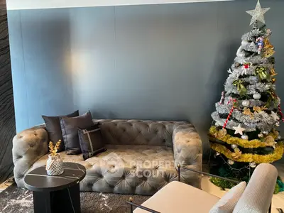 Stylish living room with plush sofa and festive Christmas tree, perfect for cozy holiday gatherings.