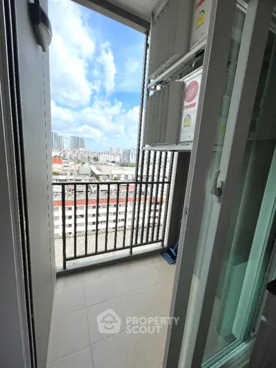 Stunning balcony view from high-rise apartment overlooking cityscape with blue skies.
